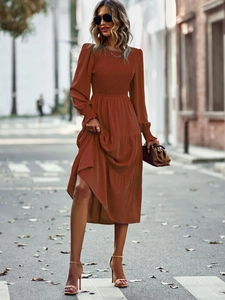 Détails de la taille smockée et de la jupe à volants sur la robe midi rouge brique
