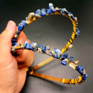 Detail of handmade gold crown headband with blue and white natural crystal stones