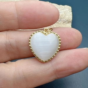 Minimalist gold heart pendant featuring a white opal stone and beaded edge detail