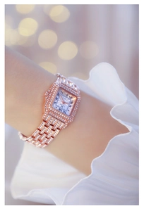 Detailed view of women's rose gold square watch featuring crystals and Roman numerals