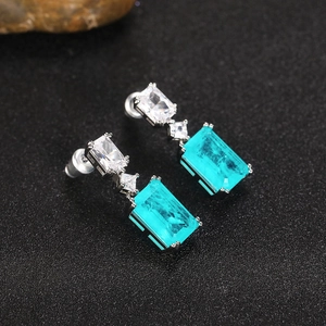 Macro detail of Paraiba blue gemstone earrings with square zircon in silver setting