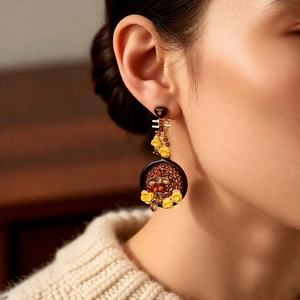 Detail of vintage flower and bee earrings on a model wearing a beige sweater