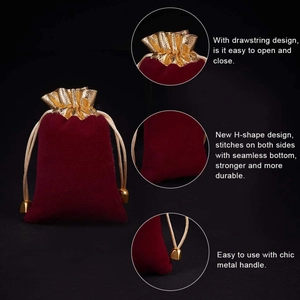 Red velvet jewelry drawstring bag with gold trim and metal handle on black background