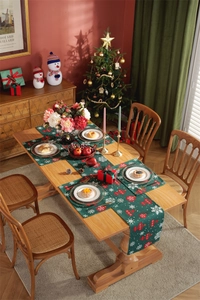 Detail of Christmas table runner and mats with red festive ornaments and snowflakes