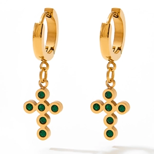 Detail of gold huggie earrings with cross drop pendants and green zircon stones