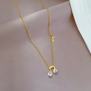 Minimalist music note necklace in gold finish with diamonds on satin fabric