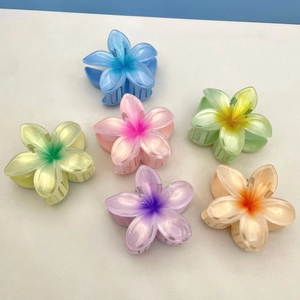 Top view of colorful plumeria hair claws in pastel blue, pink, yellow, and purple shades