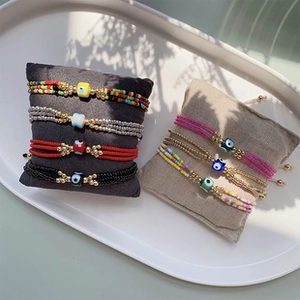 Detail of colorful Evil Eye beaded bracelets with metal spacers on display pillows