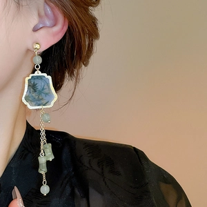 Detail view of long New Chinese style earrings with green bamboo resin patterns and jade beads