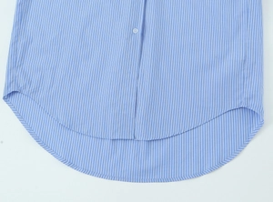 Detail of blue vertical striped shirt showing high-low curved hem and cotton fabric texture