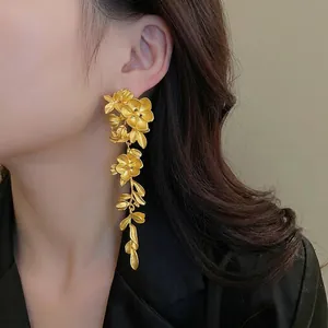 Exaggerated gold flower drop earrings with matte finish and layered petal design for women