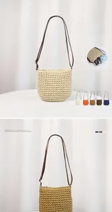 Detail view of woven straw bucket bag with synthetic leather strap and zipper closure