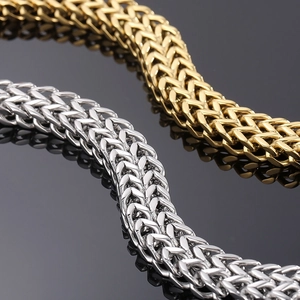 Macro shot of gold and silver double-row woven chain bracelets with sleek reflections