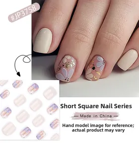 Short square press-on nails featuring purple floral patterns and gold foil accents