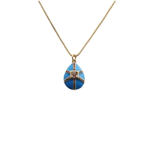 Detailed close-up of a blue enamel egg pendant with gold cross lines and colorful crystals