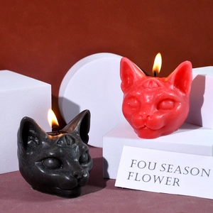 Detail of three-eyed Sphinx cat candles in red and black with Gothic atmosphere