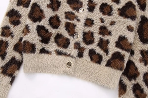 Detail der Strickjacke mit Leopardenmuster, goldenen Knöpfen und flauschiger Textur