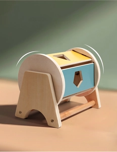 Detail of wooden Montessori shape rolling drum with colorful geometric cutouts and natural finish