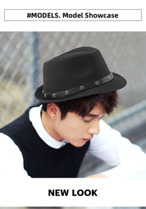Detail of black wool fedora featuring leather band with silver skull studs on model