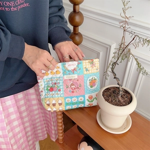 Detailed close-up of a colorful quilted cotton toiletry bag with cute cartoon patches