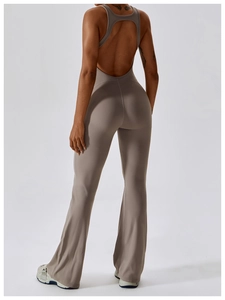 Detail of taupe backless yoga jumpsuit showing large cutout design and flared leg style