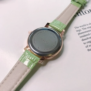 Close-up of stainless steel back case G4472 and green leather strap of the women watch