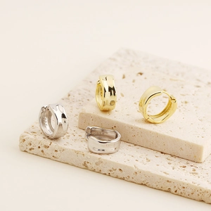 Detailed macro view of S925 sterling silver stamp on gold and silver hoop earrings