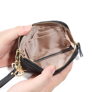 Portamonete nero in pelle con cerniera dorata e vista interna degli slot per carte