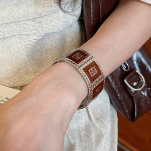 Detailed macro shot of vintage wide silver bracelet with brown geometric enamel modules
