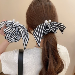 Detail of striped bow scrunchie with large white pearls and sparkling diamond accents