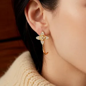 Vintage gold-plated C-shaped flower earrings with zircon pavé worn by a model