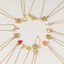 Detail of assorted gold-plated charms with strawberry, heart, and star zircon elements