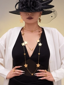 Chic layering of 18k gold plated star necklaces and earrings worn by a fashion model