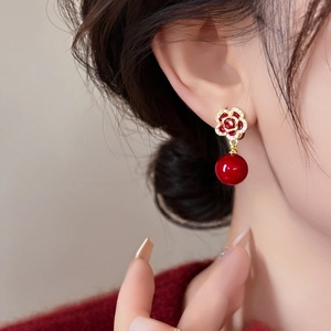 Détail de boucles d'oreilles fleur rose rouge en argent doré avec zircons et perles