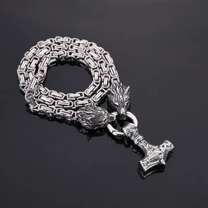Detail of viking wolf heads and mjolnir pendant on silver byzantine stainless steel chain