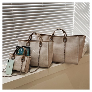 Detailed comparison of three-piece beige canvas bucket bag set with brown leather trim