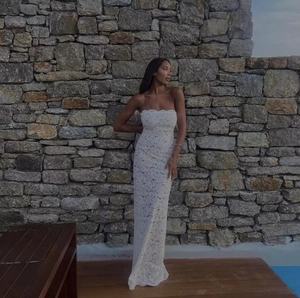 Gedetailleerde close-up van de witte kanten borduurtextuur op een strapless jurk