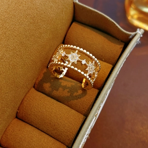 Macro shot of gold double-layer hollow star ring with cubic zirconia on velvet