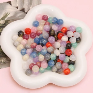 Sparkling colorful resin apple beads in a white star ceramic dish for DIY jewelry