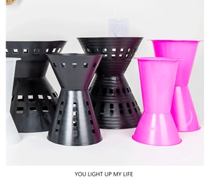 Detail of hourglass plastic flower buckets with hollow design in black, pink and white