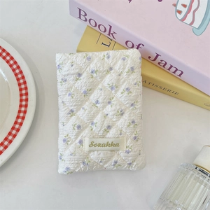 Close-up of floral quilted passport holder featuring a vintage Sozakka woven label
