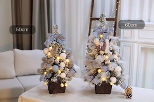 Close-up of 50cm and 60cm mini snowy Christmas trees with LED lights and bows