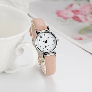 Elegant women's quartz watch with pink leather strap and white dial in a lifestyle setting