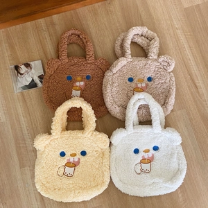 Flat lay display of cute lamb wool tote bags in four colors with bear embroidery