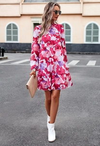 Détail d'une robe fleurie avec jupe à volants superposés et manches longues élégantes