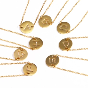 Collection détaillée de colliers en acier doré avec pendentifs lettres ajourées de A à H