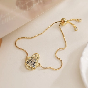 18K gold plated Mary pendant bracelet with blue and white zircons on warm beige background