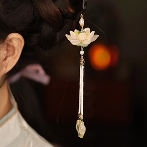 Dettaglio di un fermaglio per capelli a loto con nappe di perline e petali in vetro