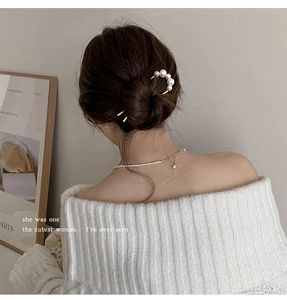Elegant U-shaped gold hairpin with five gradient pearls styled in a low hair bun