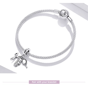 Detail of S925 silver charm bracelet featuring barber themed scissors and comb pendants
